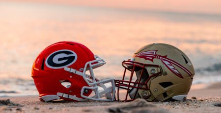 A Georgia Football Helmet and Florida State Football Helmet on the Beach